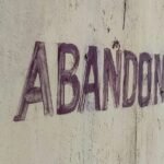 a sign that reads abandoned on a concrete wall